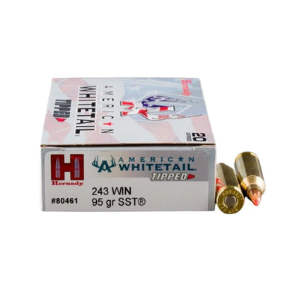 A box of Hornady American Whitetail Tipped 243 Win 95 gr SST ammunition with two loose cartridges displayed next to it on a plain white background.